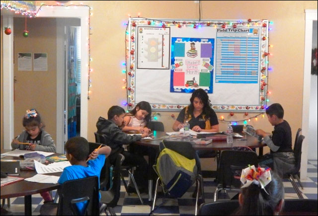 After School Homework Club with adult and children working at a table