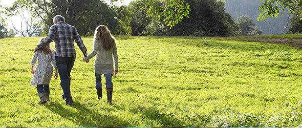 Couple with daughter walking through the grass