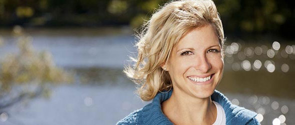 Young woman smiling at camera near stream