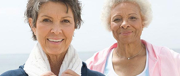 Two senior women staring at camera smiling